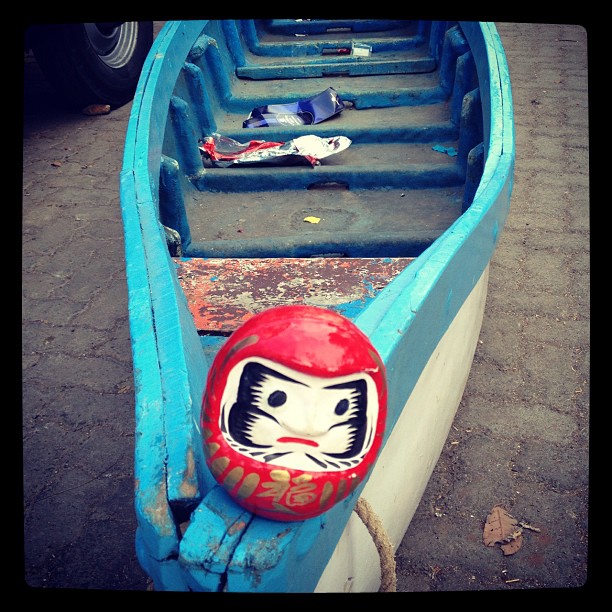 Daruma sitting on a blue boat